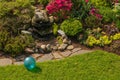 Backyard Garden Stone Fountain With Bright Turquoise Blue Childhood Toy Ball In Spring Sunlight