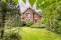 Backyard with green grass, trees and evergreens of a traditional