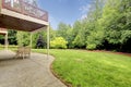 Backyard of the houes with porch and green forest.