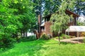 Backyard house with wooden trim and marquee, well kept lawn