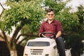 Backyard lawncare man portrait - Smiling worker using ride on grass mower Royalty Free Stock Photo