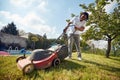 Backyard Oasis: Man Tending to the Lawn Beside the Pool