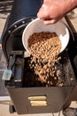 Backyard smoker adds pellets for the next project Royalty Free Stock Photo