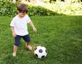 Backyard soccer. A sweet little boy with a soccer ball in the backyard.