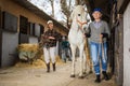 Backyard of the stables on typical autumn day - horse walking and tidying up territory Royalty Free Stock Photo