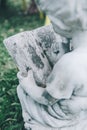 Backyard Statue Decorations on a sunny day the boy statue is sitting reading a book.Close up white stone boy angel statue in cute