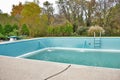 Backyard swimming pool with diving board and ladder emptied out shutting down for winter Royalty Free Stock Photo
