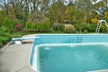 Backyard swimming pool with diving board and ladder emptied out shutting down for winter Royalty Free Stock Photo