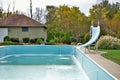 Backyard swimming pool with diving board pool slide and ladder emptied out shutting down for winter Royalty Free Stock Photo