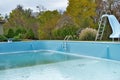 Backyard swimming pool with diving board pool slide and ladder emptied out shutting down for winter Royalty Free Stock Photo