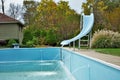 Backyard swimming pool with diving board pool slide and ladder emptied out shutting down for winter