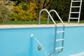 Backyard swimming pool with ladder emptied out shutting down for winter Royalty Free Stock Photo