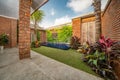 Backyard with swimming pool in stylish home. Luxury tropical villa with orange brick walls. Fine trimmed lawn Royalty Free Stock Photo