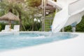 Backyard swimming pool with a water slide curving down into a refreshing swimming pool Royalty Free Stock Photo