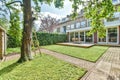 a backyard with a tree and a lawn and a Royalty Free Stock Photo