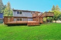 Backyard view of grey rambler house with upper and lower decks Royalty Free Stock Photo