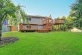 Backyard view of grey rambler house with upper and lower decks Royalty Free Stock Photo