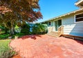 Backyard view of small American house with red brick patio area