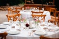 Backyard wedding reception - round tables with white tablecloths, vintage lanterns, roses and hyacinth,  and bentwood chairs Royalty Free Stock Photo