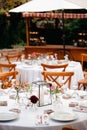 Backyard wedding reception - round tables with white tablecloths, vintage lanterns, roses and hyacinth,  and bentwood chairs Royalty Free Stock Photo