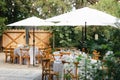 Backyard wedding reception - round tables with white tablecloths, vintage lanterns, roses and hyacinth,  and bentwood chairs Royalty Free Stock Photo