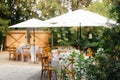 Backyard wedding reception - round tables with white tablecloths, vintage lanterns, roses and hyacinth,  and bentwood chairs Royalty Free Stock Photo