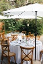 Backyard wedding reception - round tables with white tablecloths, vintage lanterns, roses and hyacinth,  and bentwood chairs Royalty Free Stock Photo