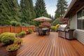 backyard wooden deck of a craftsman home with stone grill