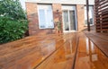 Backyard wooden deck floor boards with fresh brown stain Royalty Free Stock Photo