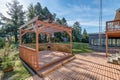 Backyard wooden deck pergola two story home in summer