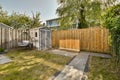 a backyard with a wooden fence and a shed and Royalty Free Stock Photo