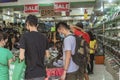 Baclaran, Paranaque, Metro Manila, Philippines - Two men purchase shoes at a budget store at the main market area