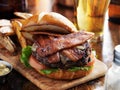 Bacon burger with pretzel bun and beer Royalty Free Stock Photo