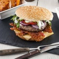 Bacon cheese bbq burger on wooden table with fries Royalty Free Stock Photo