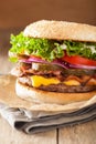 Bacon cheese burger with pickles tomato onion Royalty Free Stock Photo