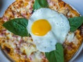 Bacon cheese pizza with basil and egg on top Royalty Free Stock Photo
