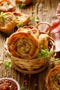 Bacon and cheese puff pastry pinwheel in a basket on a wooden table, close up view. Royalty Free Stock Photo