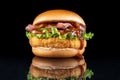 Bacon cheeseburger hamburger isolated on black. BBQ sauce and lettuce. The sauce flows nicely. Royalty Free Stock Photo