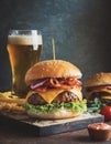 Bacon cheeseburger with red onion topping and lettuce salad