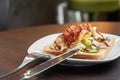 A bacon and egg sandwich on a white plate with a fork and knife. Copy space Royalty Free Stock Photo