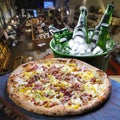 Bacon pizza, beer in an ice bucket