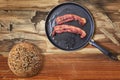 Fried Bacon Rashers In Teflon Frying Pan With Integral Brown Bread Loaf Set On Old Cracked Flaky Wooden Picnic Table