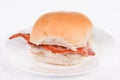 Bacon roll, bap or bun on a white plate Royalty Free Stock Photo