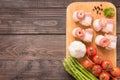 Bacon rolls with tomato, garlic, asparagus on wooden background Royalty Free Stock Photo
