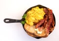 Bacon,scrambled eggs and toast in cast iron skillet white backgorund Royalty Free Stock Photo