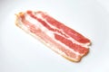 Bacon strip, raw smoked pork meat slice isolated on white Royalty Free Stock Photo