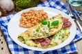 Bacon stuffed omelette with backed beans on a white plate Royalty Free Stock Photo