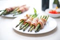 bacon-wrapped asparagus bundles on a white plate Royalty Free Stock Photo