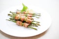 bacon-wrapped asparagus bundles on a white plate Royalty Free Stock Photo