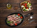 Bacon wrapped asparagus on wooden table.  Cooking asparagus. Food background. Asparagus served on cast-iron frying pan with fresh Royalty Free Stock Photo